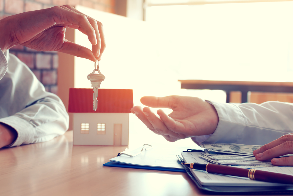Landlord handing keys to property manage